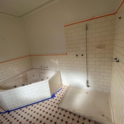 Bathroom under renovation with white subway tiles, jet bathtub, and shower area.