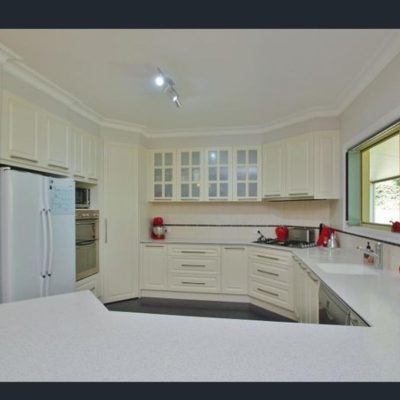 Modern kitchen with resurfaced white cabinetry and red appliances.