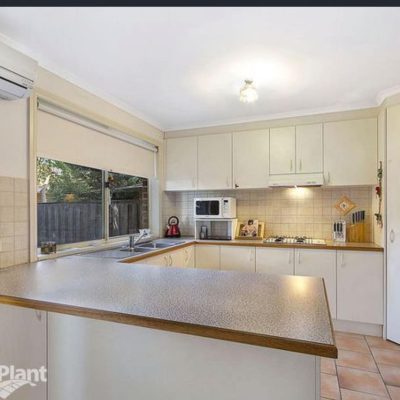 Modern kitchen featuring light-colored cabinets, stainless steel appliances, and a spacious benchtop.