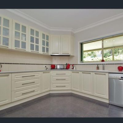 U-shaped kitchen with white cabinets and red appliances including a stand mixer, kettle, and toaster.