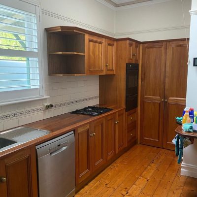 Classic kitchen with wooden cabinets, gas stovetop, built-in oven, stainless steel dishwasher, and white tiled backsplash.