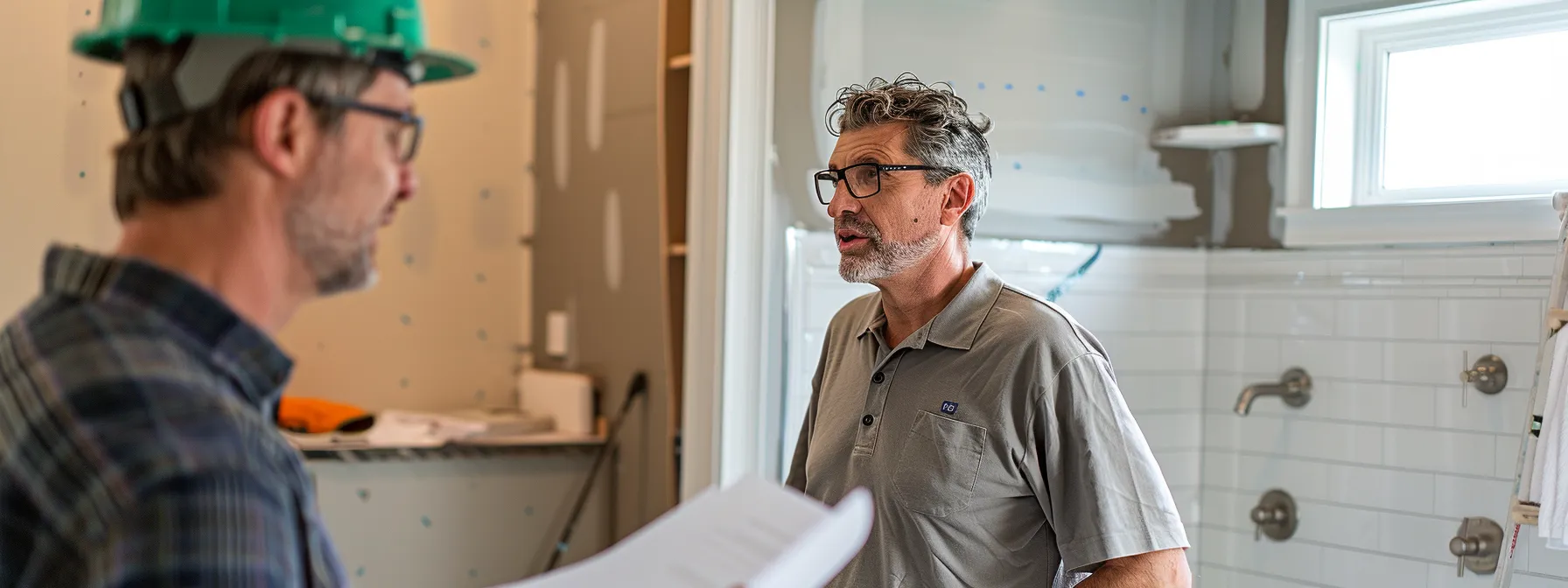 a contractor discussing bathroom renovation plans with a homeowner.