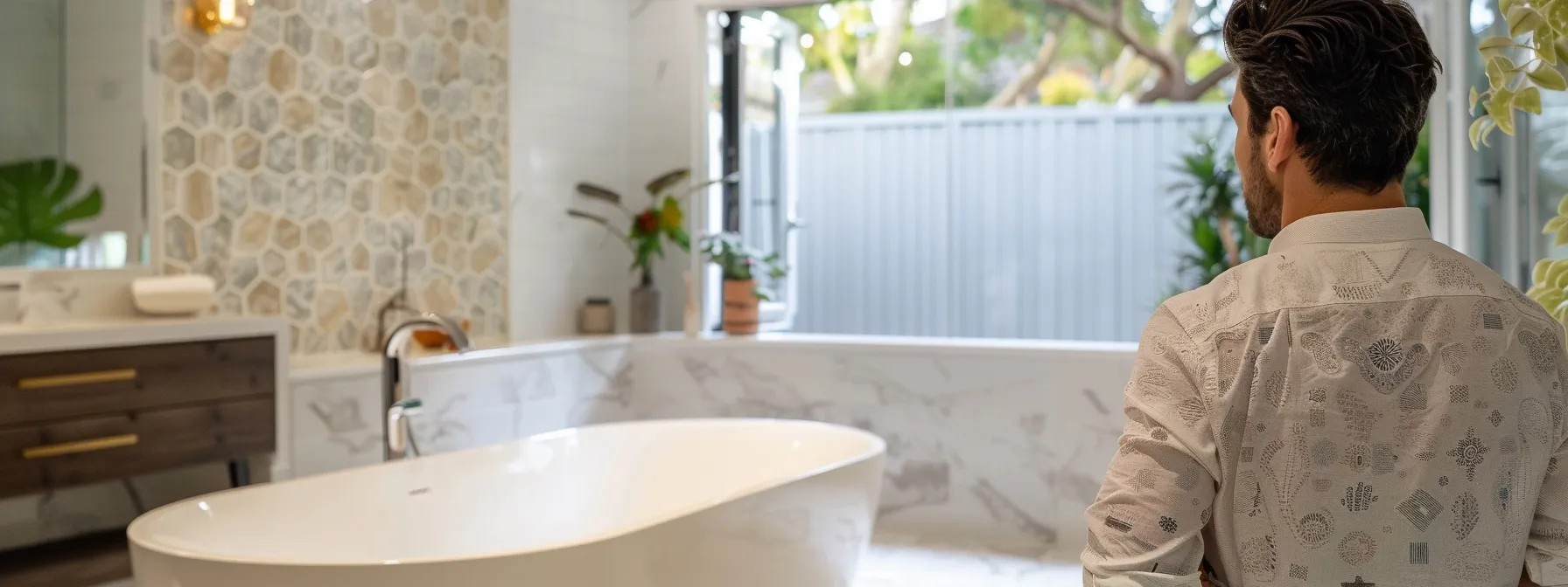 a client observing a beautifully renovated bathroom with a bathtub and stylish tiles, discussing renovation ideas with a contractor while examining the overall design of the room.